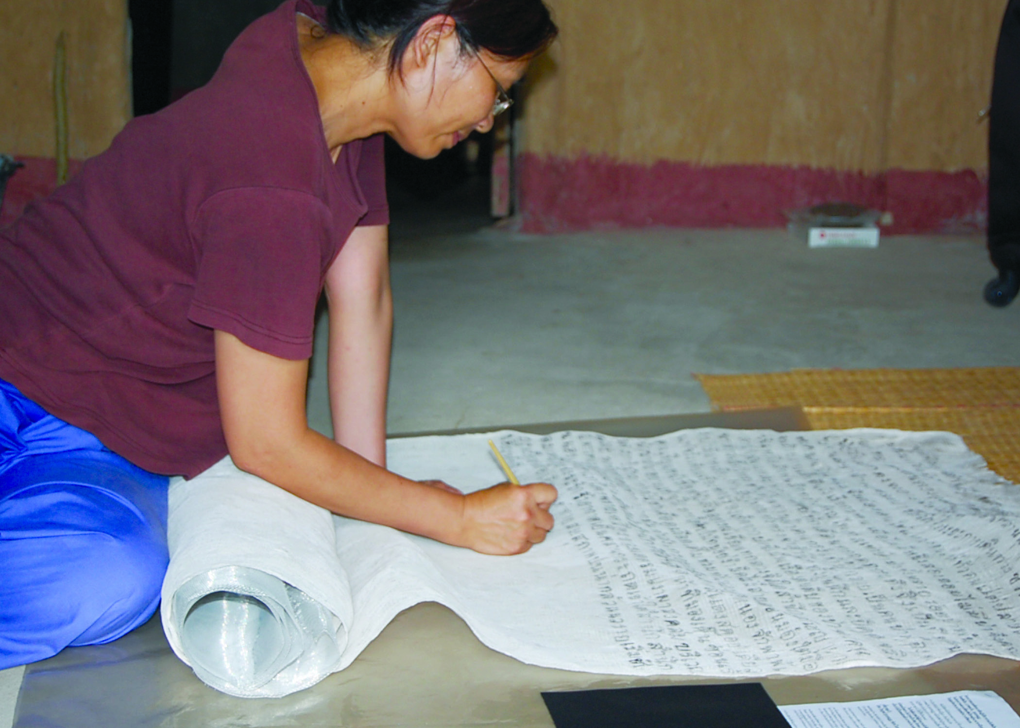 2woman writing on scroll on the floor side on.
