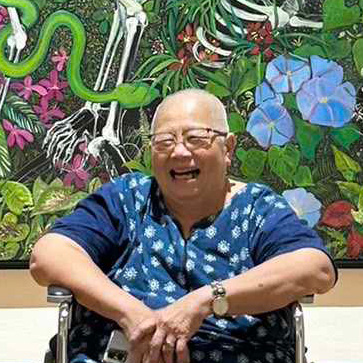 woman sitting in front of painting wearing bright blue clothing