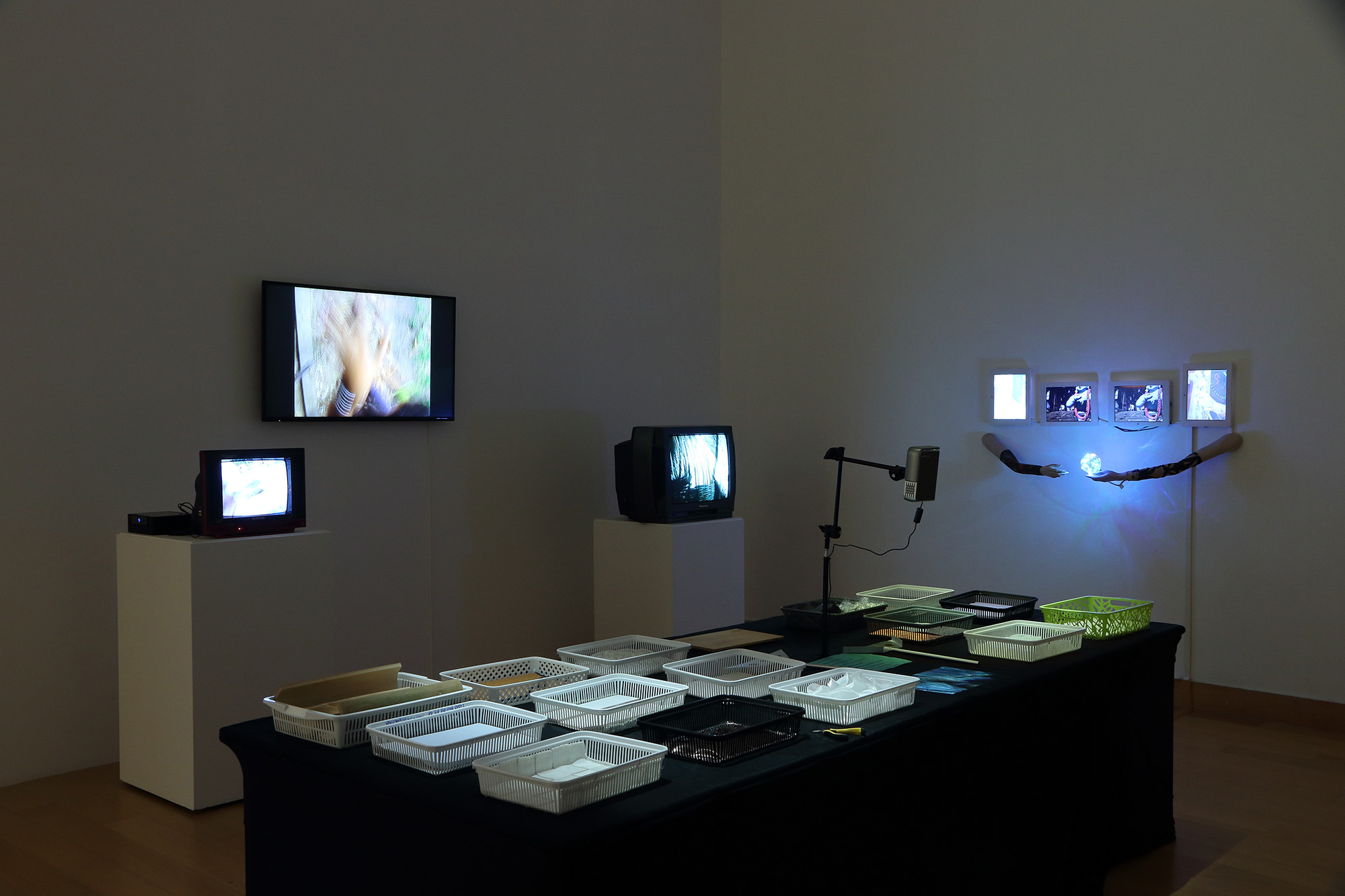 dark room with brightly lit screens and a table in the middle