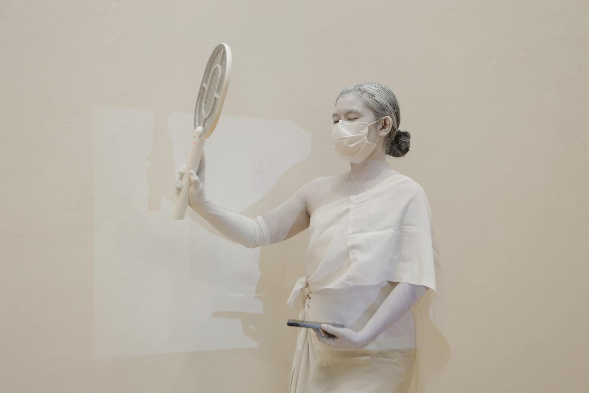 woman in white holding a fan